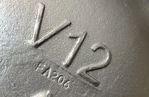 Detalle del marcaje de modelo y referencia sobre el cuerpo fundido